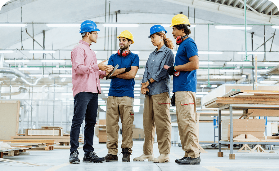 Workers discussing in a factory setting.